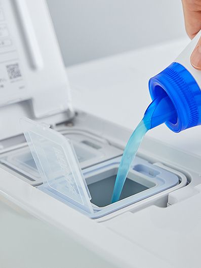 液体洗剤タンクに、洗剤を入れている写真